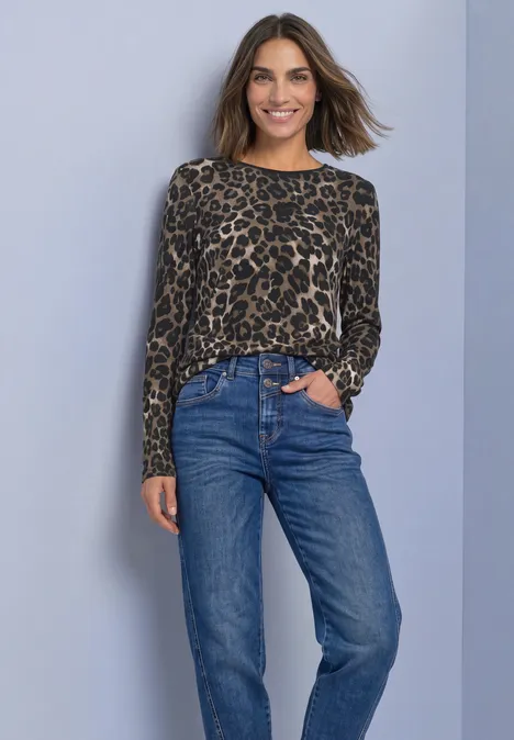 Langarm Shirt mit Rundhals und Leo-Muster Black Frau trägt Leoparden-Print-Pullover und blaue Jeans vor neutralem Hintergrund.