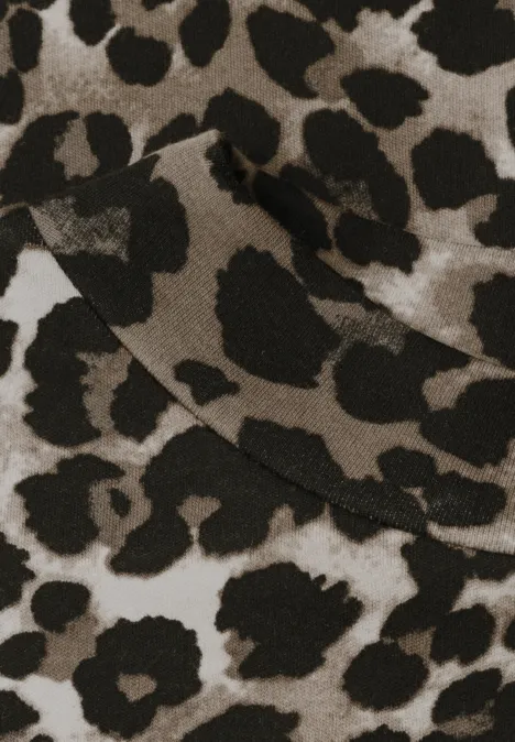 Gros plan d’un tissu beige avec un imprimé léopard noir distinct.