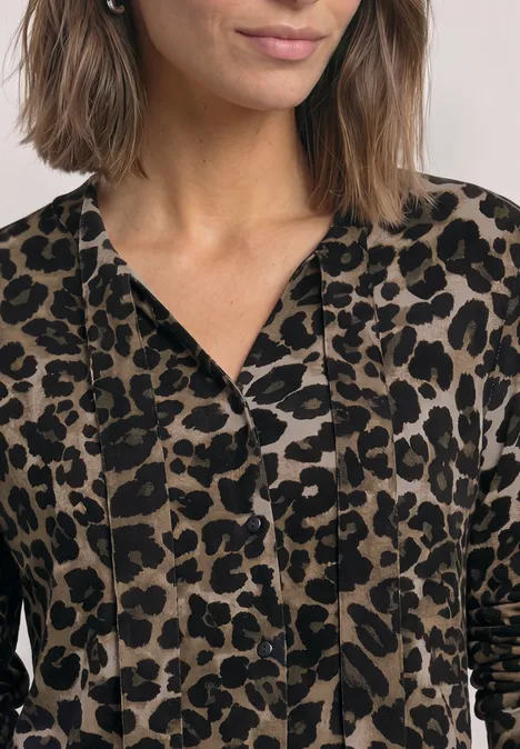 Langarm Shirt im Blusen-Look mit Leo-Muster Black Eine Frau trägt ein langärmeliges Oberteil mit Leopardenmuster.