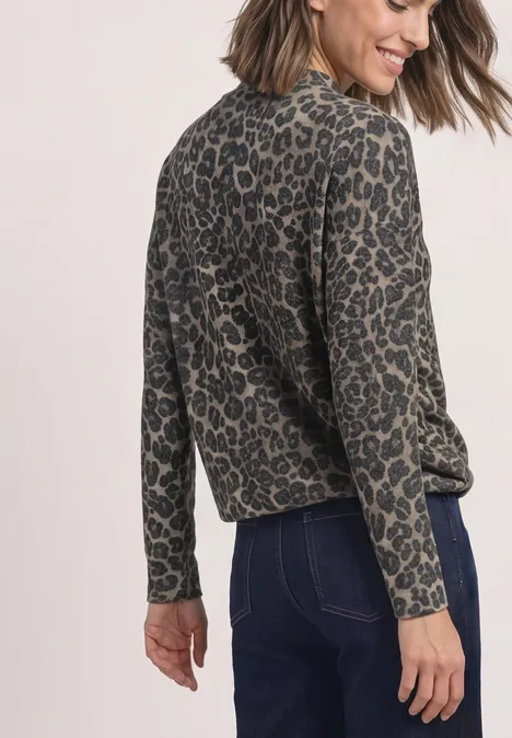 Langarm Shirt mit Turtle neck und Leo-Muster Black Frau trägt lockeres, langärmeliges Oberteil mit Leopardenmuster und dunkle Jeans von hinten.