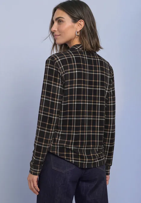 Langarm Shirt im Blusen-Look mit Karomuster Black Frau trägt karierte Bluse mit langen Ärmeln, dunkle Hose, blickt über Schulter.