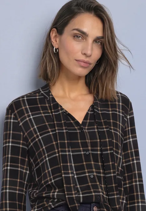 Langarm Shirt im Blusen-Look mit Karomuster Black Frau mit schulterlangem braunem Haar und schwarz-beige karierter Bluse vor schlichtem grauem Hintergrund.