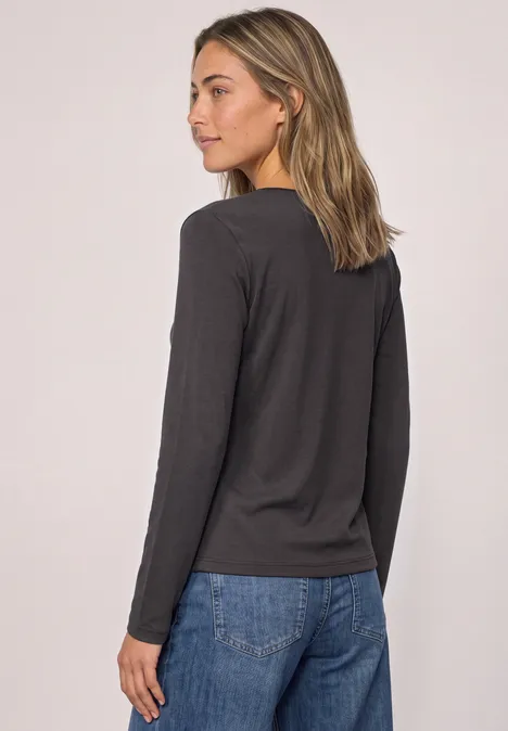 Shirt met lange mouwen, ronde hals en satijndetail black coffee Vrouw in zijaanzicht met donkergrijze longsleeve en een blauwe spijkerbroek.