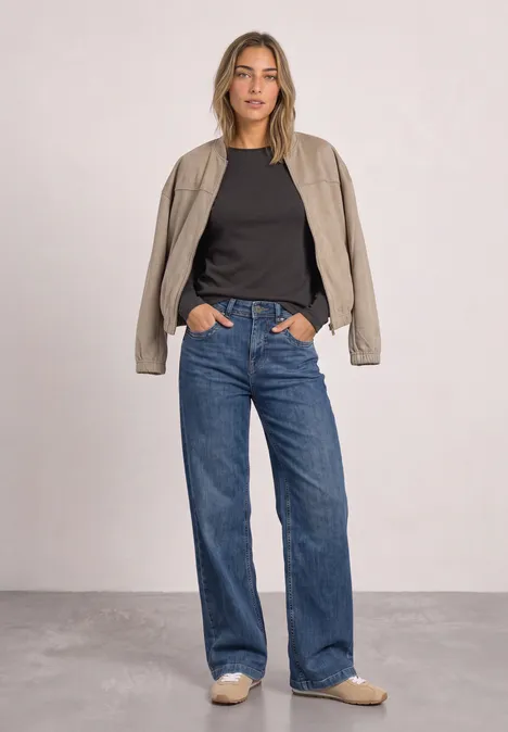 Shirt met lange mouwen, ronde hals en satijndetail black coffee Vrouw in casual look: zwart t-shirt, beige overhemd, wijde blauwe jeans en bijpassende loafers.