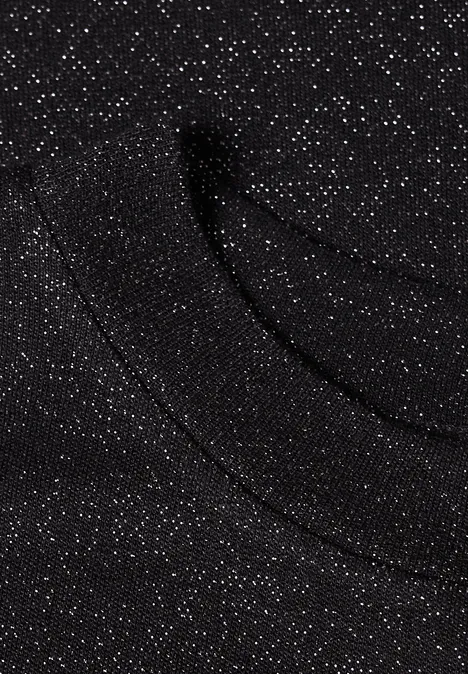 Schwarzer Stoff mit silbernen Glitzpunkten, funkelt dezent und zeigt eine sanfte, geschwungene Textur.