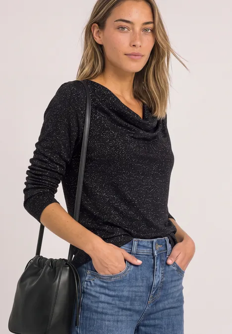 Langarm Shirt mit Wasserfallfront Black Frau trägt schwarzen, langärmligen Pullover mit Wasserfallkragen, blaue Jeans und schwarze Umhängetasche, halbporträt.
