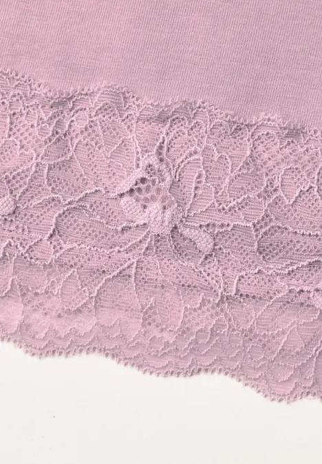 Gros plan d’un tissu rose orné d’une dentelle florale.