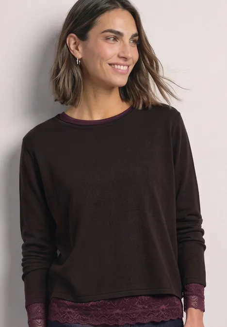 Shirt met lange mouwen, boothals en kant berry plum Lachende vrouw in bruin langarmtrui met kanten rand, lichte achtergrond.