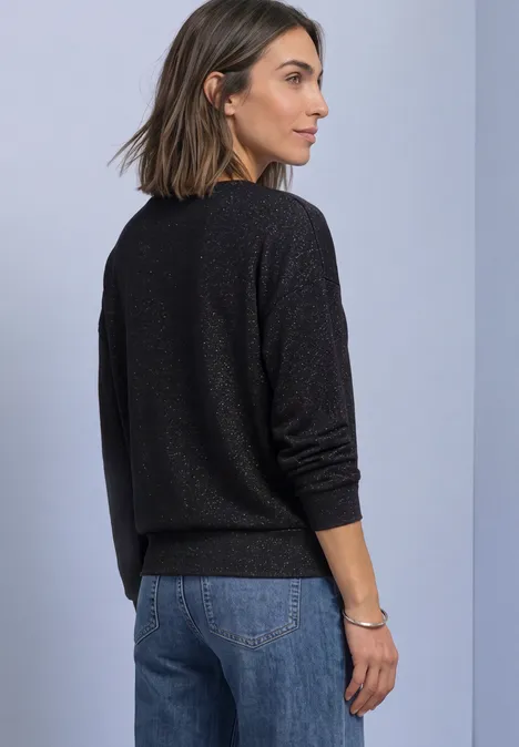 Shirt met gebreide look en vleermuismouwen Black Vrouw in zwart trui en spijkerbroek, zijaanzicht tegen een neutrale achtergrond.