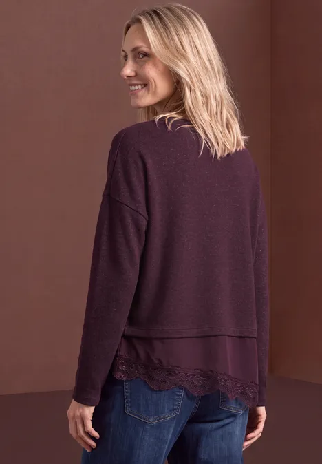 T-shirt avec bordure en dentelle biseautée berry plum mel. Rückansicht einer Frau in locker sitzender, lila Strickjacke mit Spitzenbesatz am Saum.