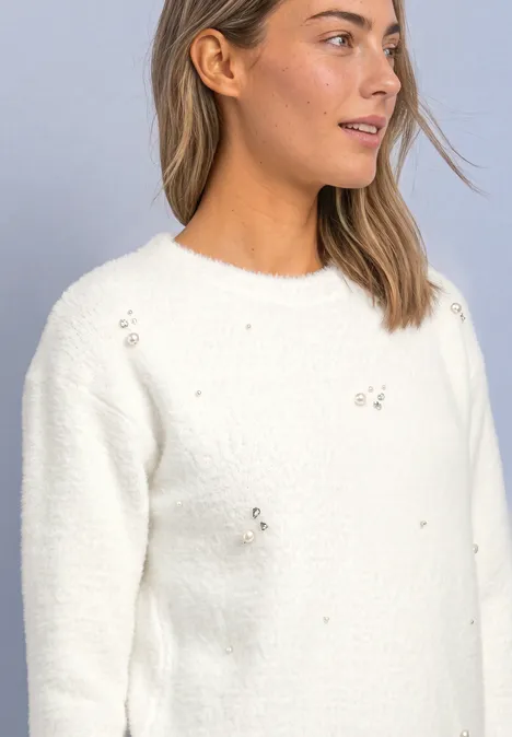 3/4-Arm Shirt mit dekorativen Details off white Junge Frau in weißem Strickpullover mit dezenten Applikationen vor grauem Hintergrund.