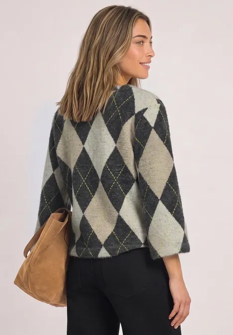 Frau mit argyle Strickpullover und Schultertasche, seitlich vom Rücken abgebildet.