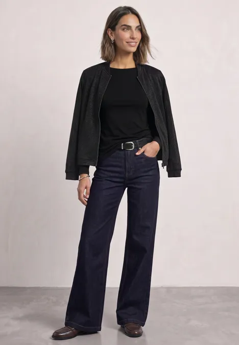 Leichter Blouson mit Glitzerdetails Black Frau in schwarzer Jacke, schwarzem Shirt und weitem, dunklen Jeanshose vor hellem Hintergrund.