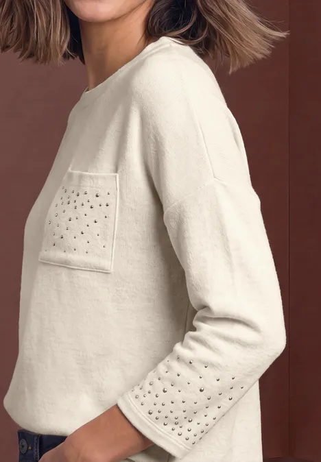 Shirt met 3/4-mouwen en siersteentjes clay sand mel. Beiger Pullover mit Brusttasche und Lochmuster auf Tasche und Ärmeln, seitliche Ansicht.