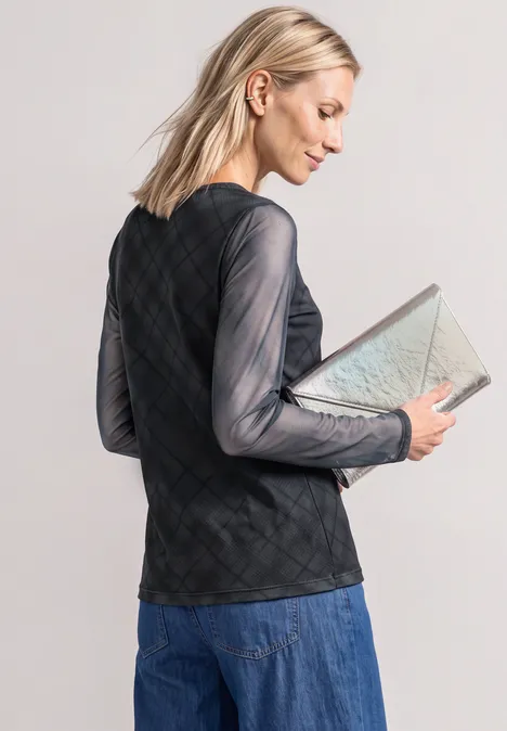 Langarm Shirt aus Mesh mit Karomuster armor grey Frau mit blonden Haaren in schwarzem, transparentem Rautentop und Jeansrock hält beige Clutch.