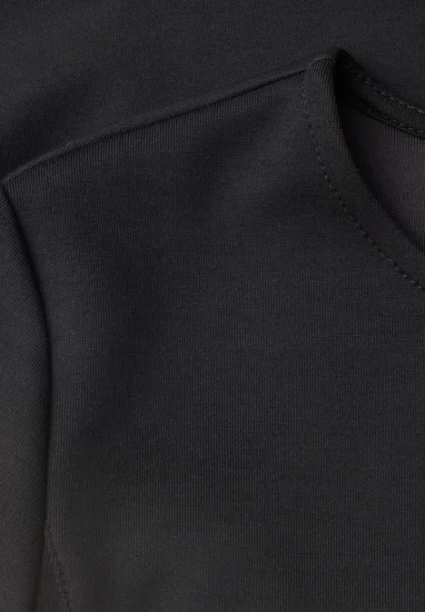 Langarm Shirt mit Volant-Saum Black Nahaufnahme eines schwarzen Kleidungsstücks mit sichtbarer Naht