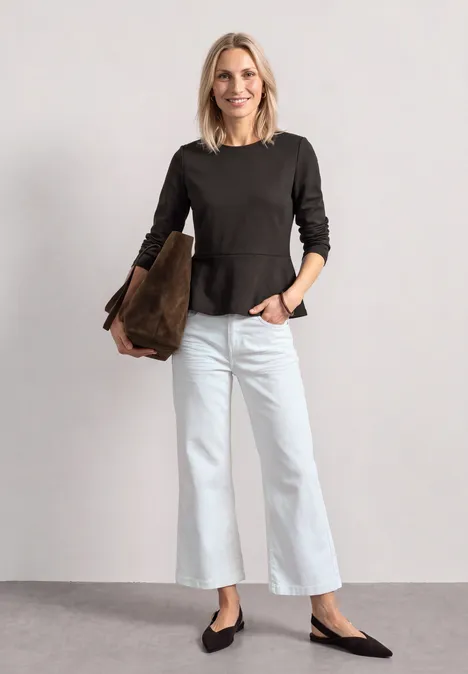 Langarm Shirt mit Volant-Saum black coffee Eine Frau vor hellem Hintergrund trägt dunkelgraues Oberteil, weiße weite Hosen, schwarze Ballerinas, braune Tasche.