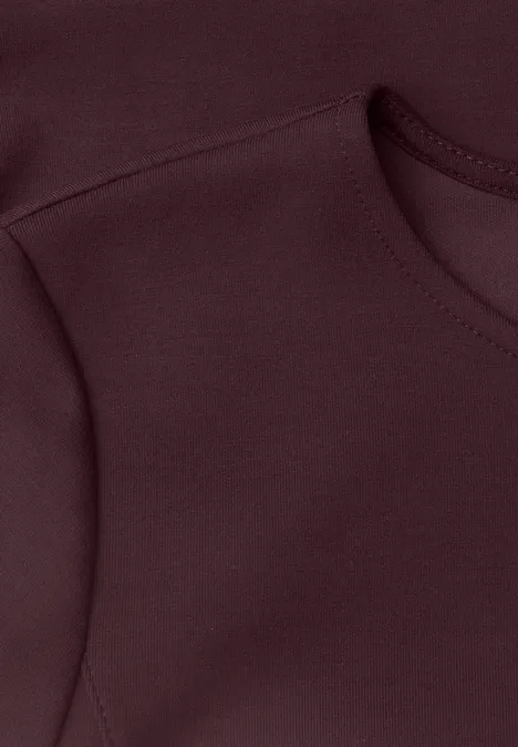 Langarm Shirt mit Volant-Saum berry plum Nahaufnahme eines burgunderroten Kleidungsstücks mit sichtbarer Naht und Rundhalsausschnitt.