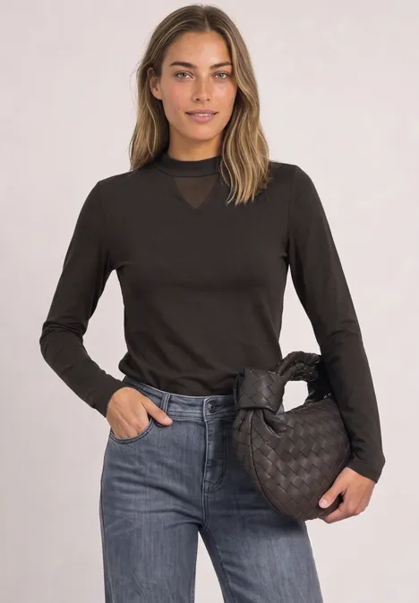 Shirt met lange mouwen, col en mesh-detail black coffee Jonge vrouw in zwarte longsleeve, spijkerbroek en gestept zwarte handtas voor een lichte achtergrond.