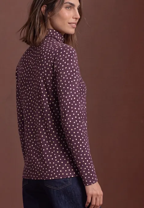 Basic Shirt mit Rollkragen und Muster berry plum Seitliche Ansicht einer Frau in lila, gepunktetem Langarmshirt und Jeans vor braunem Hintergrund.