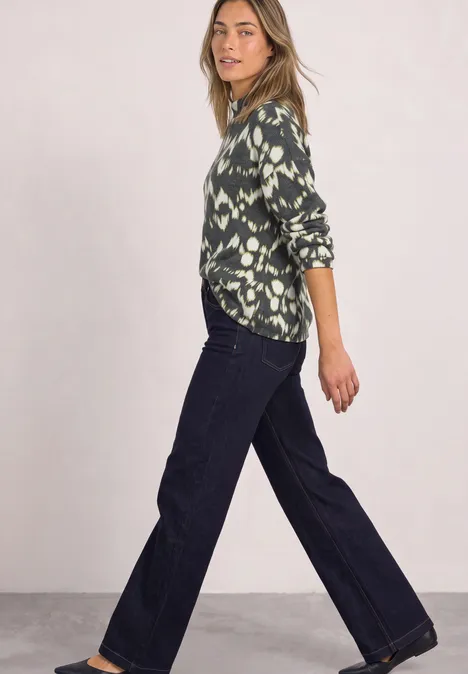 Shirt met lange mouwen, col en print Black Vrouw in groene, gebloemde blouse en wijde jeans, in zijaanzicht poseerend voor een lichte achtergrond.