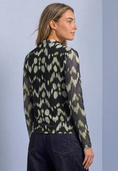 Shirt van mesh met col en print Black Eine Frau von hinten in einer gemusterten, halbtransparenten Langarmbluse vor schlichtem Hintergrund.