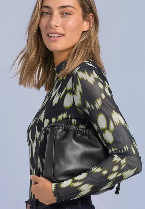 Shirt van mesh met col en print Black Eine Frau im Halbporträt trägt ein gemustertes Oberteil und hält eine schwarze Handtasche.