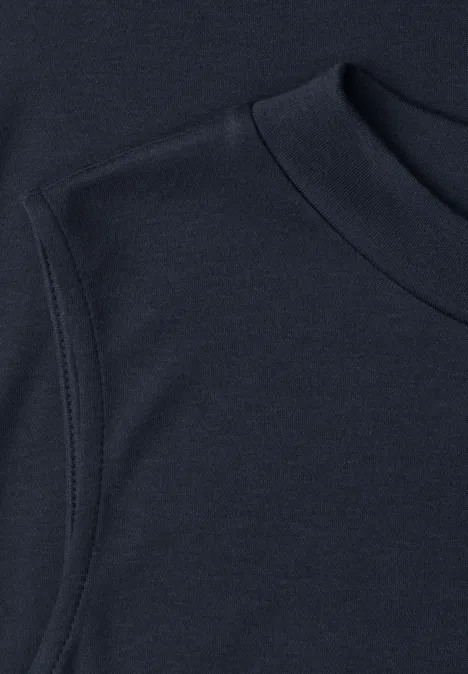 Basic top shadowed navy Close-up van een donkerblauw t-shirt met ronde hals en nette mouwnaad.