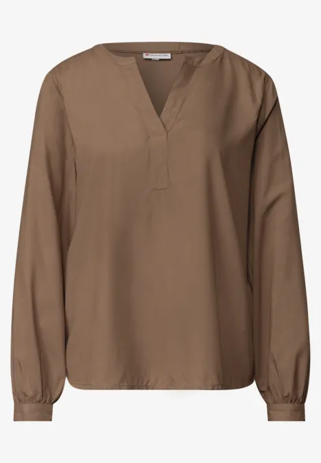 Braune Bluse mit V-Ausschnitt und langen Ärmeln, locker sitzend.