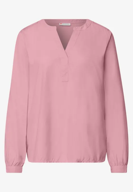 Rosa Bluse mit V-Ausschnitt, langen Ärmeln und elastischen Bündchen.