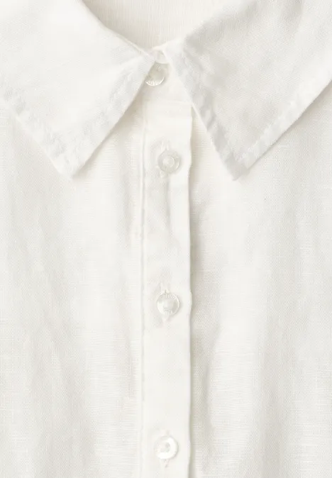 Close-up van een wit overhemd met knopenrij en klassieke kraag.