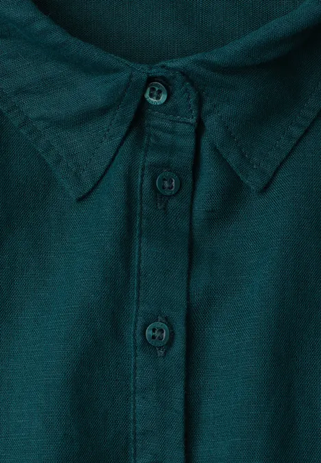 Close-up van de kraag van een donkergroen overhemd met knoopsluiting en drie zichtbare knopen.