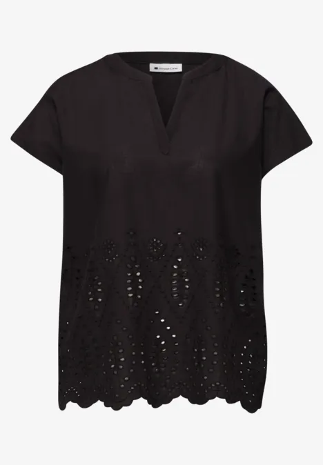 Losvallende zwarte blouse met korte mouwen, V-hals, geborduurd ajour en golvende zoom.