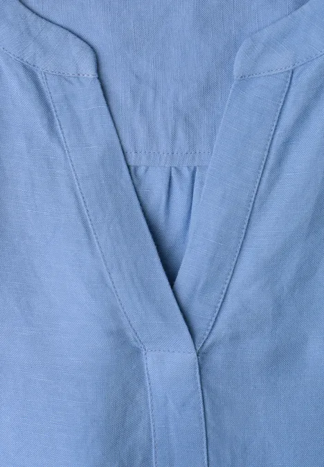 Helles Blau, V-Ausschnitt mit feinen Nähten, vermutlich Teil eines Oberteils.