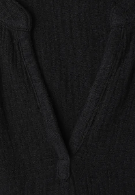 Schwarzes Oberteil mit V-Ausschnitt aus geripptem Stoff.