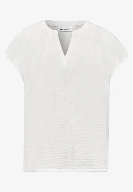 Weißes, kurzärmeliges Damenoberteil aus leicht strukturierter Baumwolle mit V-Ausschnitt.