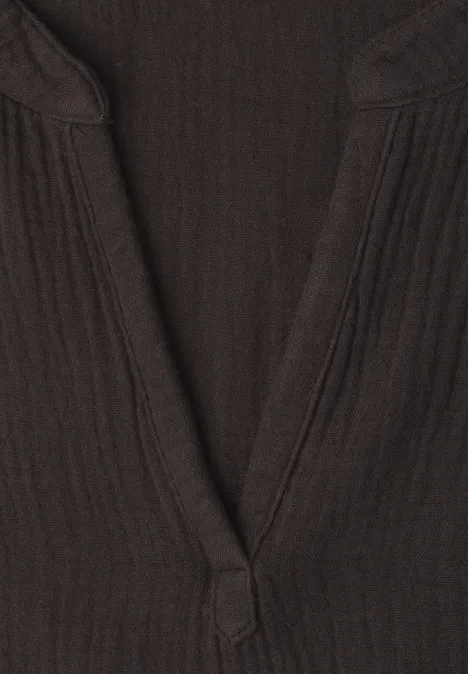 Nahaufnahme eines dunkelbraunen, gerippten V-Ausschnitts an einem Oberteil.