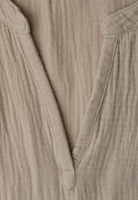 Beiges Leinen-Oberteil mit V-Ausschnitt und strukturierter Oberfläche.