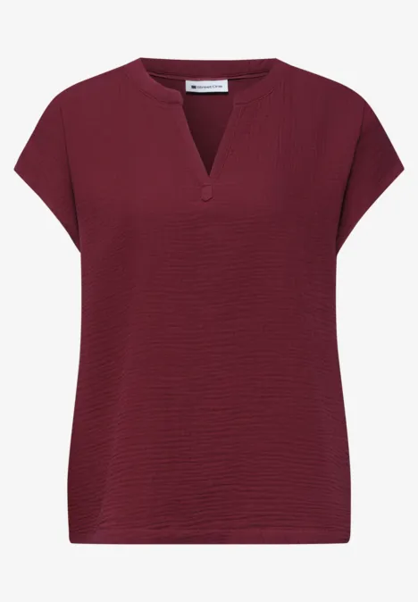 Locker geschnittenes Damen-Shirt in Dunkelrot mit gerippter Struktur und kleinem V-Ausschnitt.