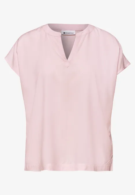 Eine zartrosa Damenbluse mit kurzem Kimono-Ärmel, V-Ausschnitt und loses, fließendes Design, schlicht und elegant.