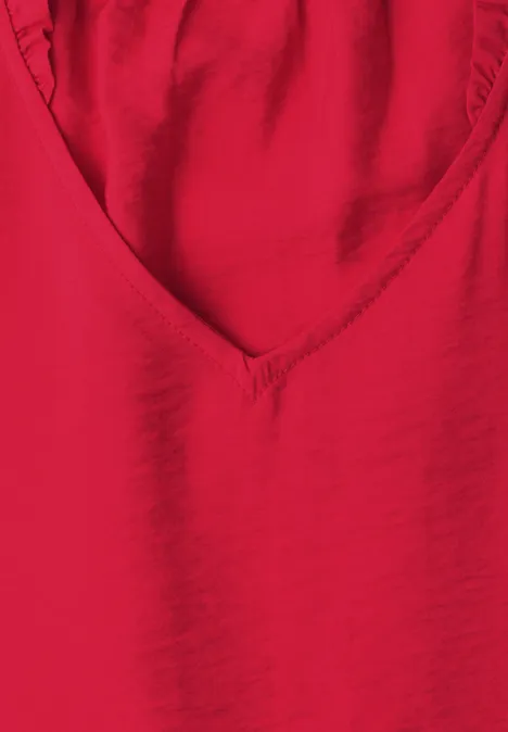 Ein rotes V-förmiges Oberteil aus glattem Stoff.