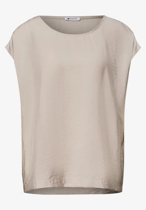Schlichtes, kurzärmeliges Damen-T-Shirt in hellem Beige mit leichtem, fließendem Stoff.