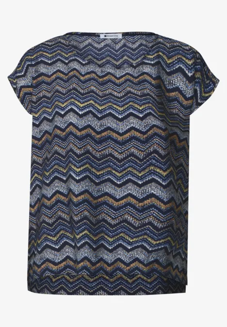 Kurze Damenbluse mit buntem Zickzackmuster in Blau, Senf und Weiß, rundem Ausschnitt und legerem Schnitt.