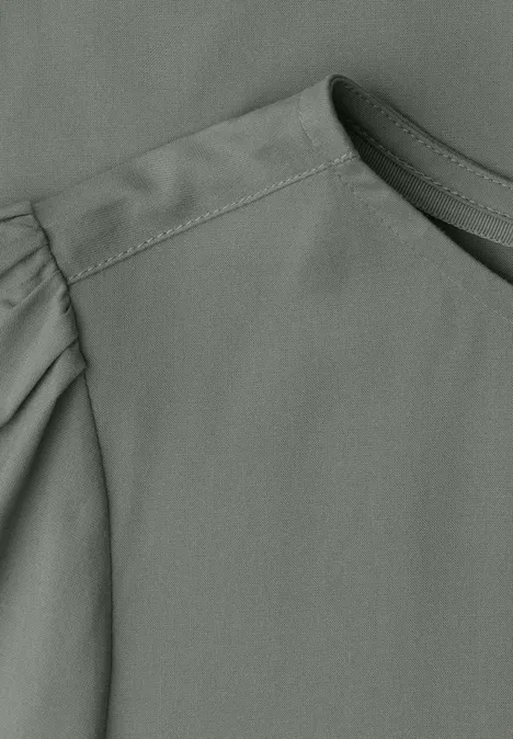 Grijs bovenstuk met ronde hals en subtiele plooien aan de mouw.
