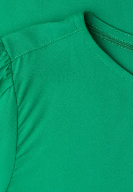 Bluse mit Rundhals und kurzen Puffärmeln ever green Nahaufnahme eines grünen T-Shirts mit Rundhalsausschnitt und leicht gerafften Ärmeln.