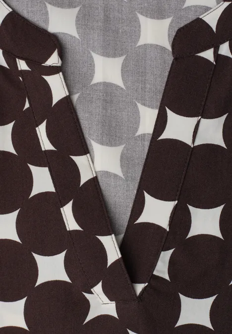 Donkerbruin wikkeltop met opvallend wit cirkel-sterpatroon.