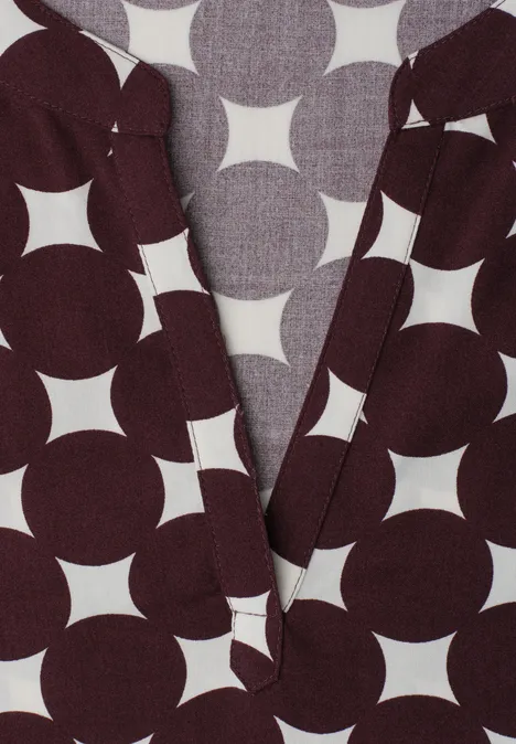 Dropped Shoulder Bluse mit Split Neck rustic rouge Dunkelbraunes Kleidungsstück mit großem geometrischem Weiß-Kreis-Stern-Muster und V-Ausschnitt