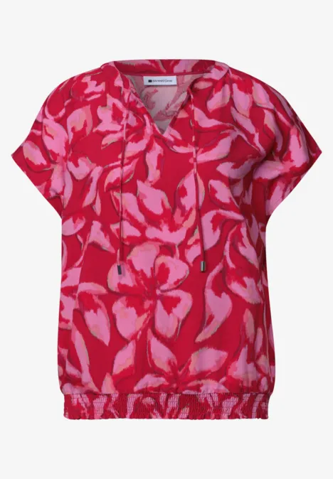 Rosa Bluse mit roten, abstrakten Blumenmustern, V-Ausschnitt und Tunnelzug am Saum.