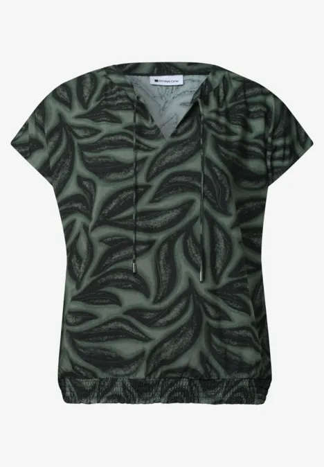 Dunkelgrünes, kurzärmeliges Damen-Shirt mit abstraktem Blattmuster.