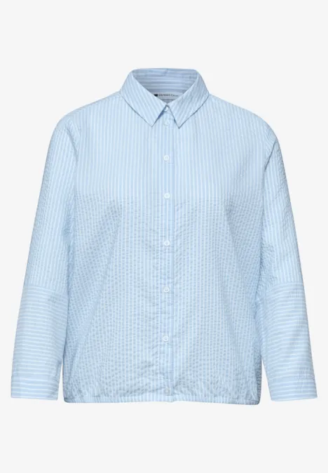 Hellblaues, langärmliges Hemd mit feinem Karomuster, Knopfleiste und lockerem Schnitt.